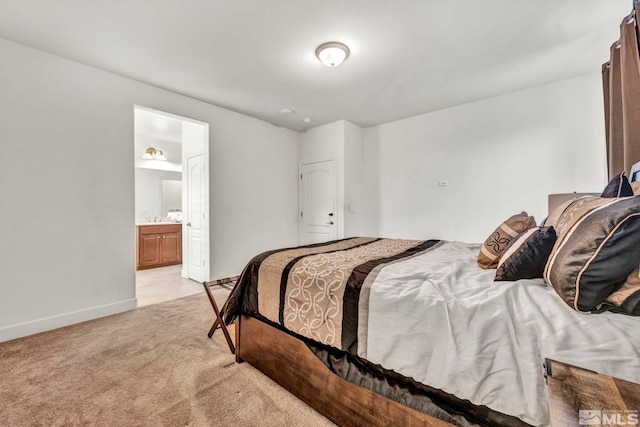 bedroom featuring ensuite bath and light carpet