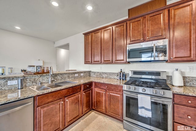 kitchen with stainless steel appliances, light stone countertops, sink, and light tile patterned floors