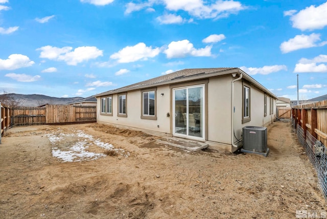 rear view of property featuring central AC unit and a mountain view