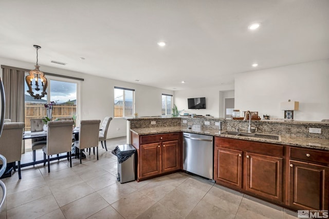 kitchen with pendant lighting, sink, stainless steel dishwasher, light tile patterned floors, and light stone countertops