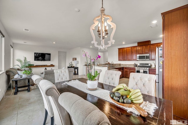 tiled dining area featuring sink and a notable chandelier