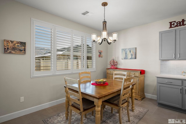 tiled dining space featuring a chandelier