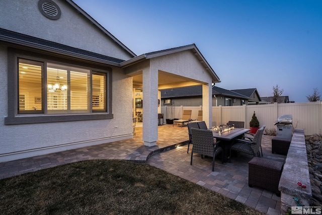 patio terrace at dusk featuring a grill and an outdoor hangout area