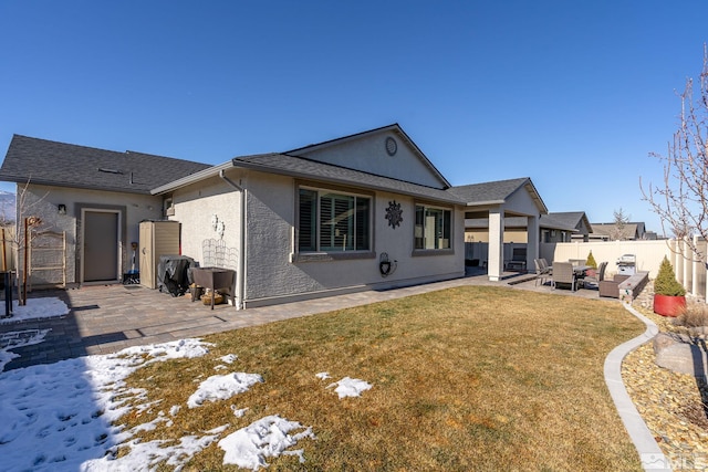 snow covered house featuring a yard, an outdoor hangout area, and a patio area