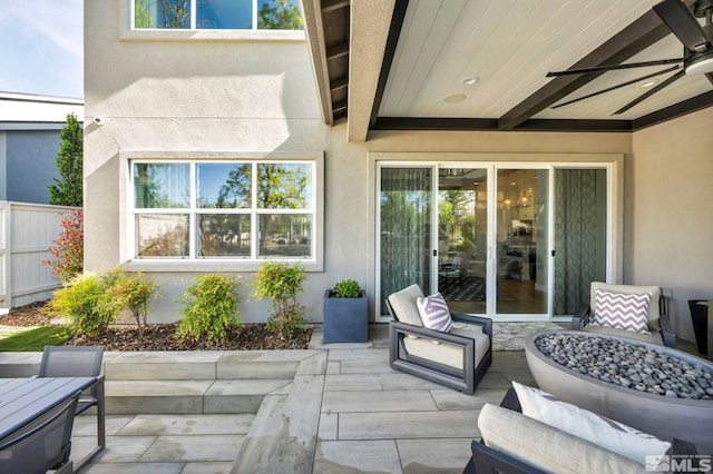 view of patio / terrace with ceiling fan and a fire pit