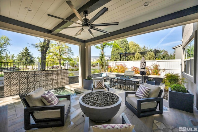 view of patio / terrace featuring ceiling fan and an outdoor living space with a fire pit