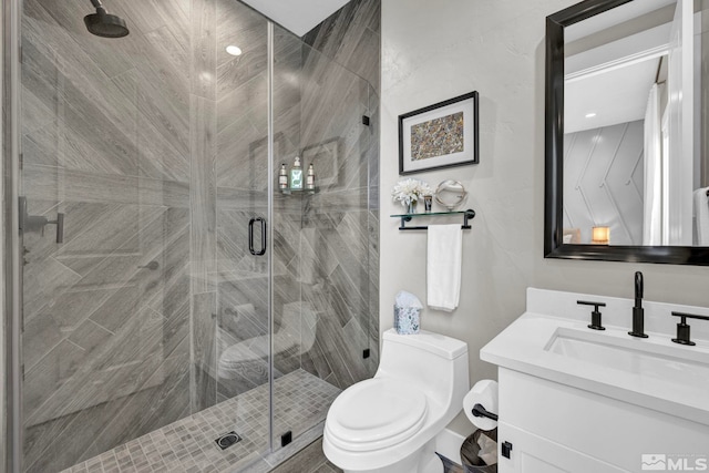 bathroom featuring vanity, toilet, and an enclosed shower