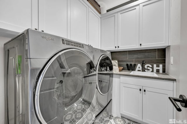 clothes washing area featuring cabinets, separate washer and dryer, and sink