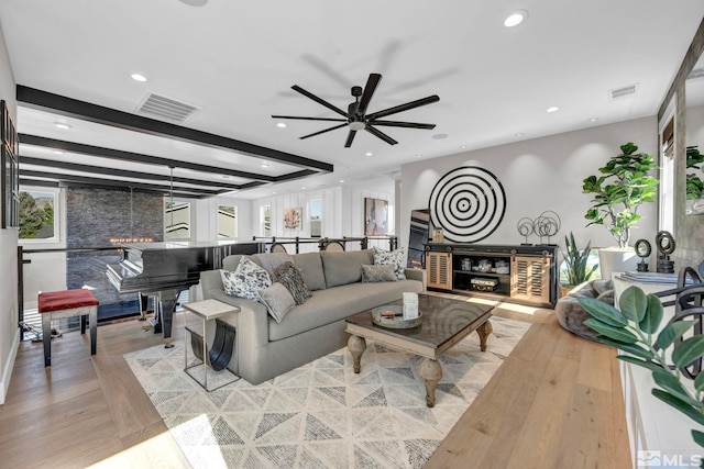 living room featuring ceiling fan, beamed ceiling, and light wood-type flooring