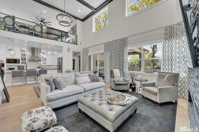 living room featuring an inviting chandelier, beam ceiling, and hardwood / wood-style flooring