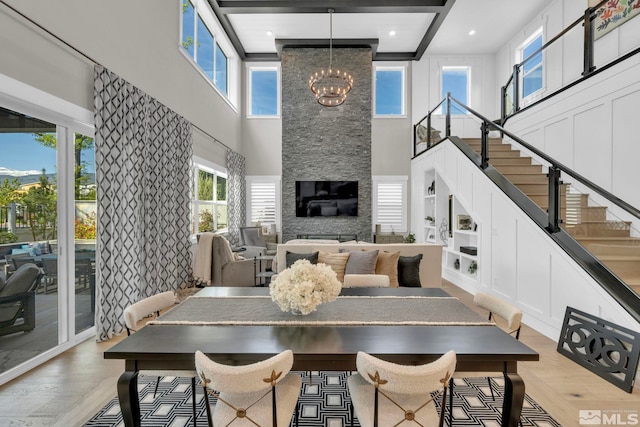 dining room featuring beam ceiling, light hardwood / wood-style flooring, built in features, and a chandelier