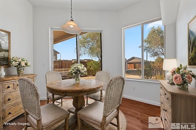 dining space featuring plenty of natural light and dark hardwood / wood-style flooring