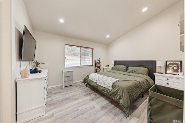 bedroom with vaulted ceiling and light wood-type flooring