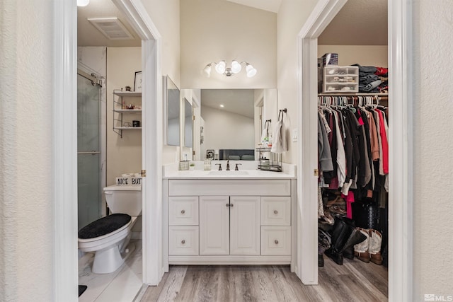 bathroom with hardwood / wood-style flooring, vanity, toilet, and an enclosed shower