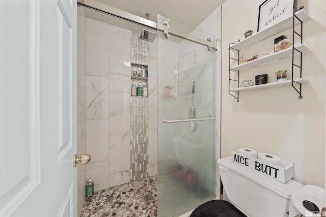 bathroom featuring a shower with door and toilet