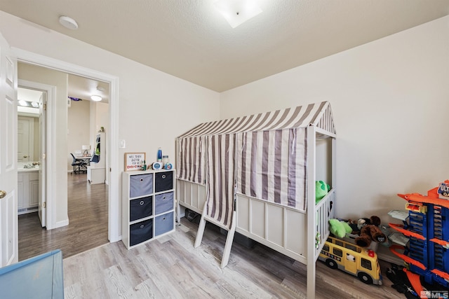 bedroom with wood-type flooring and a textured ceiling