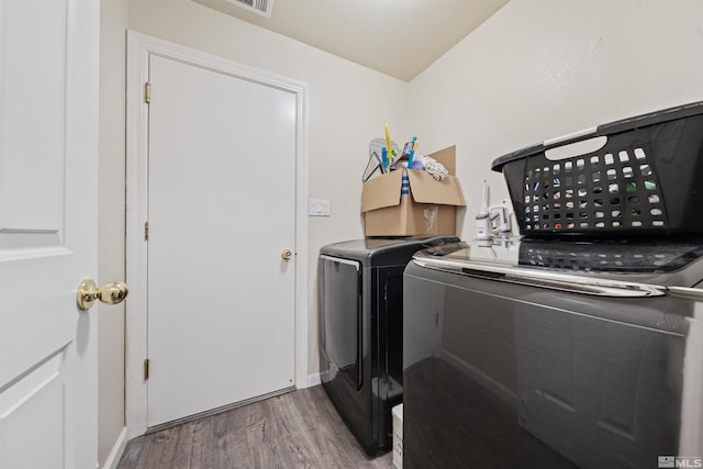 laundry area featuring washing machine and dryer and light hardwood / wood-style floors