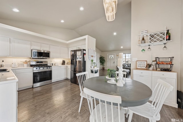 dining space featuring lofted ceiling, dark hardwood / wood-style floors, and a chandelier