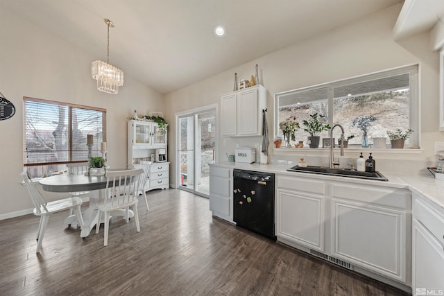 kitchen featuring pendant lighting, sink, lofted ceiling, black dishwasher, and white cabinets