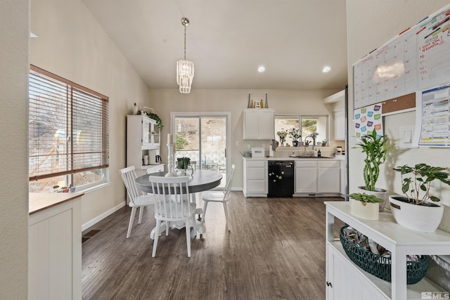 dining area featuring sink, vaulted ceiling, and dark hardwood / wood-style floors