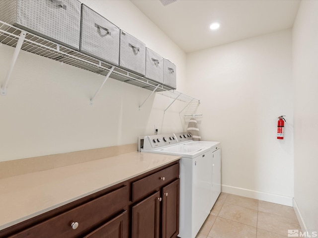 clothes washing area featuring washing machine and dryer and light tile patterned floors