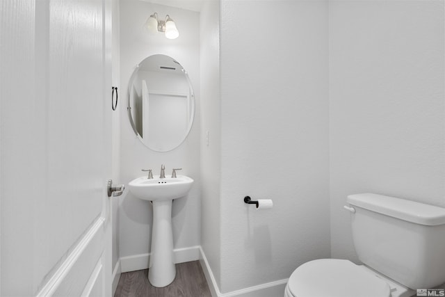 bathroom featuring wood-type flooring and toilet