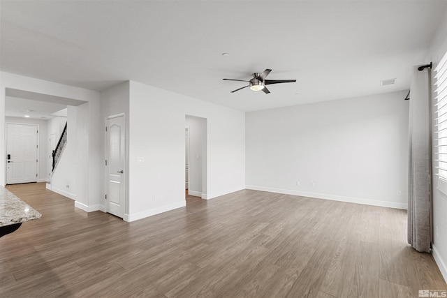 unfurnished living room with ceiling fan and hardwood / wood-style floors