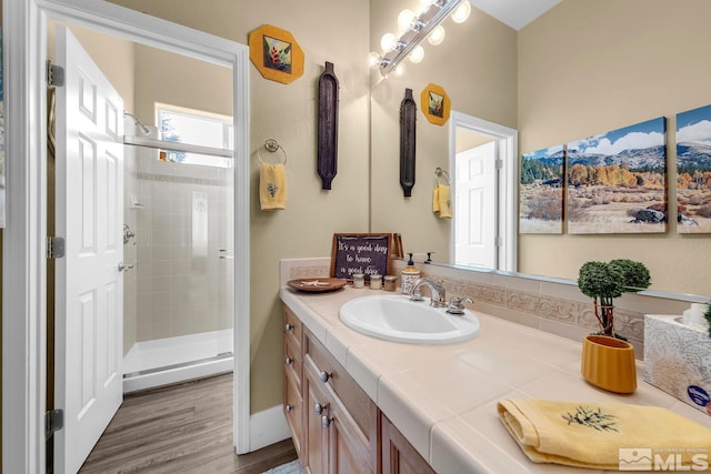 bathroom with vanity, wood-type flooring, and a shower with shower door