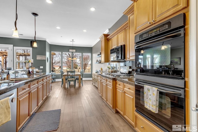 kitchen with sink, light hardwood / wood-style flooring, ornamental molding, pendant lighting, and black appliances