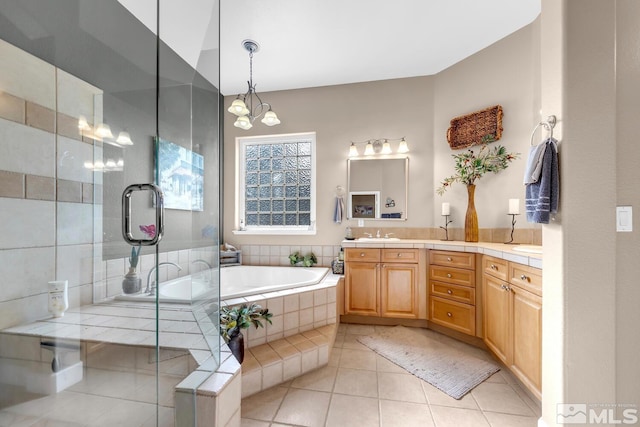 bathroom with tile patterned flooring, vanity, plus walk in shower, and an inviting chandelier