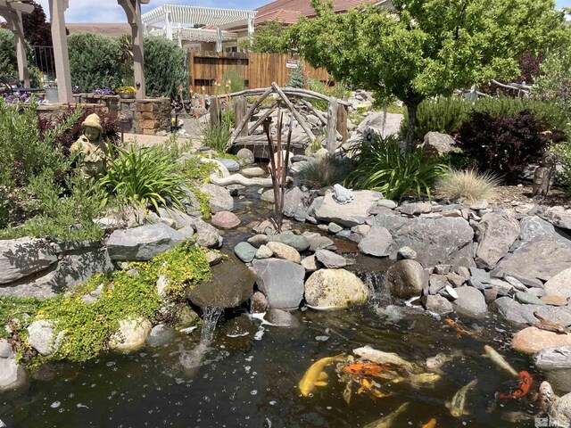 view of yard featuring a small pond and a pergola