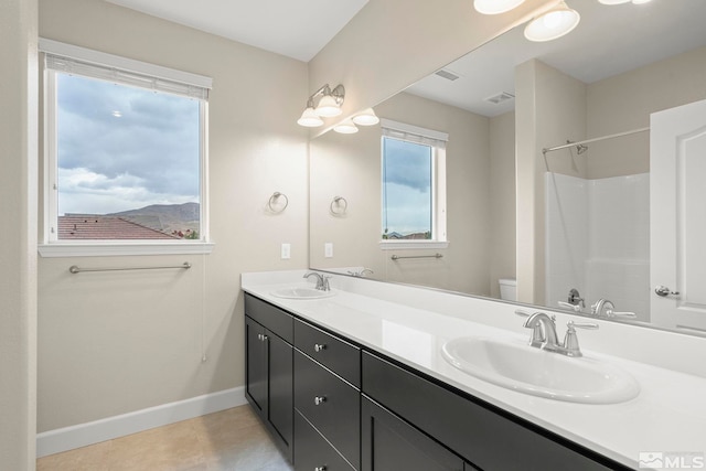 bathroom featuring tile patterned flooring, a shower, vanity, and toilet