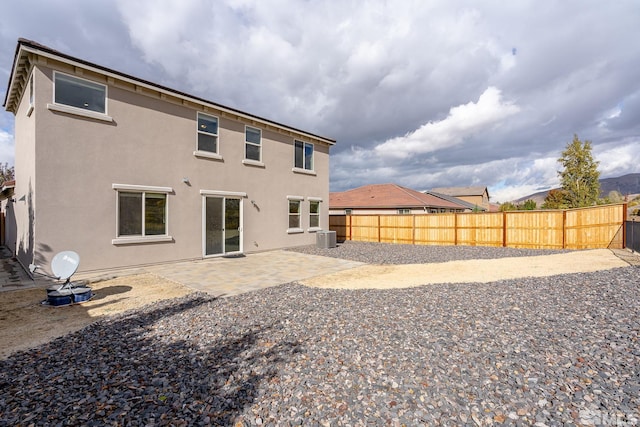 rear view of house featuring central air condition unit and a patio area