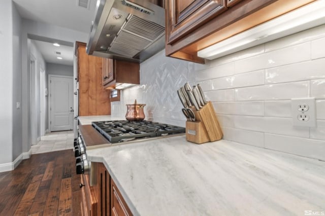 kitchen with dark hardwood / wood-style floors, ventilation hood, and backsplash