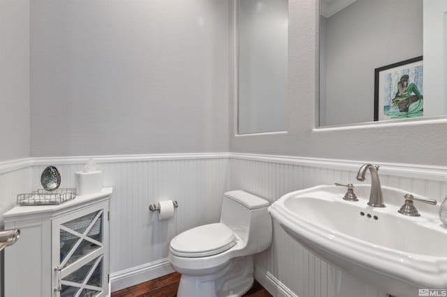 bathroom with hardwood / wood-style flooring, sink, and toilet