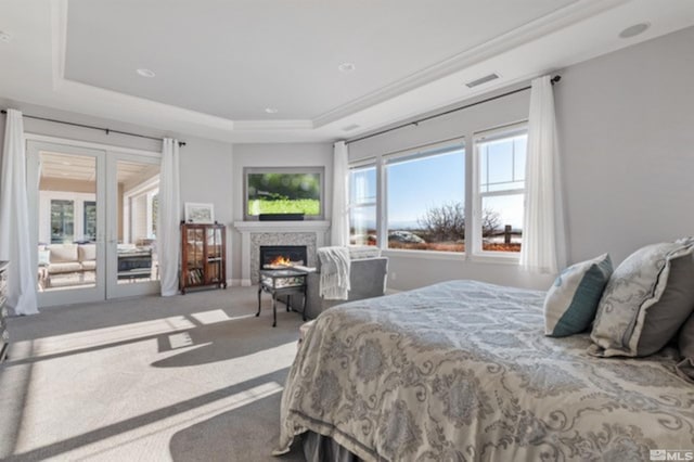 bedroom with a tray ceiling, access to outside, and carpet