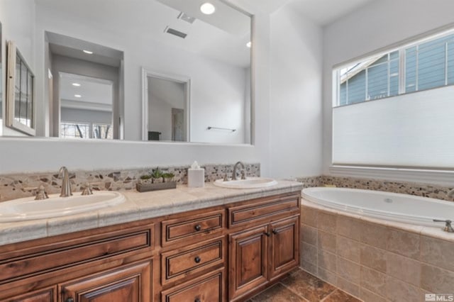 bathroom featuring vanity and tiled tub