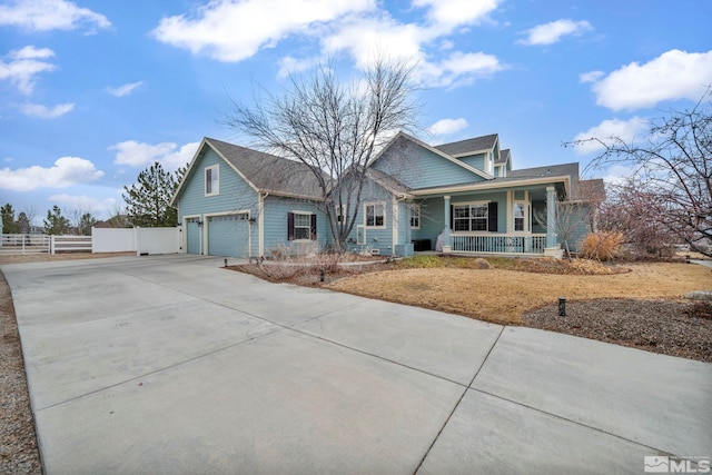 view of front of home featuring cooling unit, a garage, and covered porch