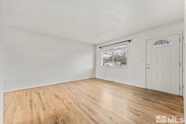 entrance foyer with light hardwood / wood-style floors and a textured ceiling