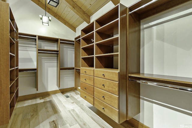 walk in closet featuring vaulted ceiling with beams and light wood-type flooring