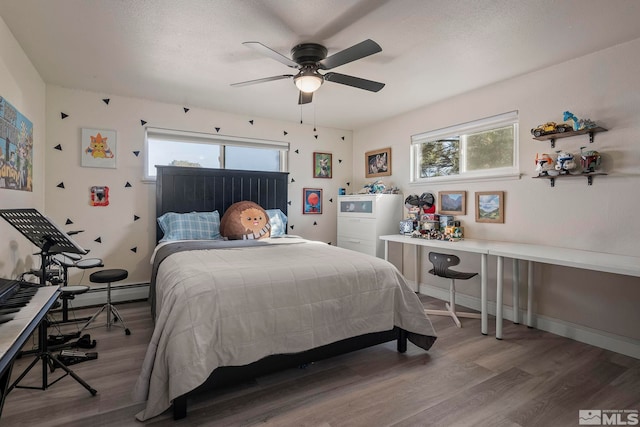 bedroom with hardwood / wood-style flooring, ceiling fan, a textured ceiling, and a baseboard heating unit