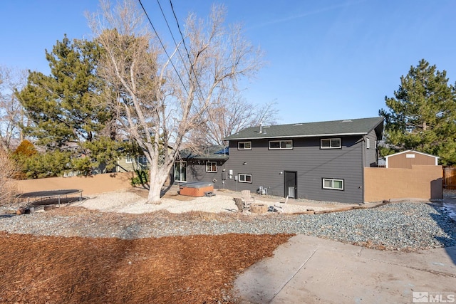 back of house with a hot tub and a patio