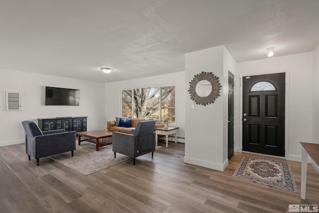 entrance foyer featuring wood-type flooring and a baseboard heating unit