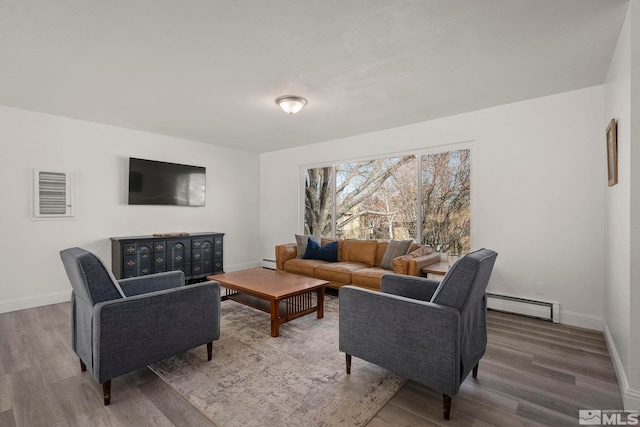 living room featuring baseboard heating and hardwood / wood-style flooring