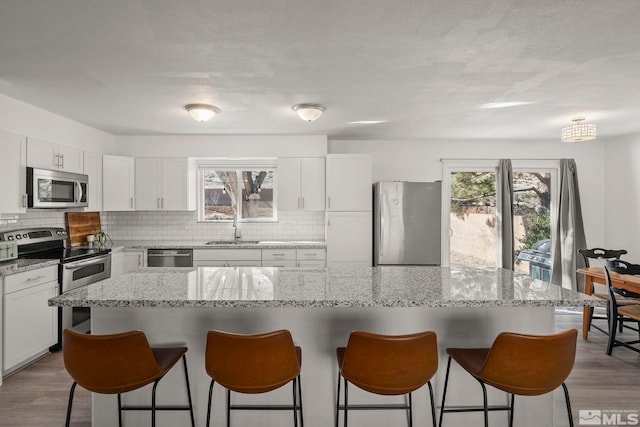 kitchen featuring sink, a center island, white cabinets, and appliances with stainless steel finishes