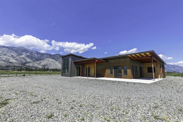 rear view of property featuring a mountain view and a patio area