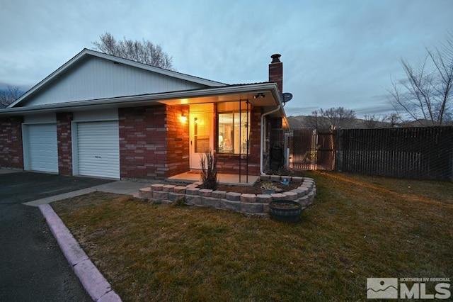 view of front of property featuring a garage and a front lawn