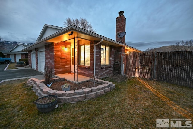 view of side of property with a garage and a lawn