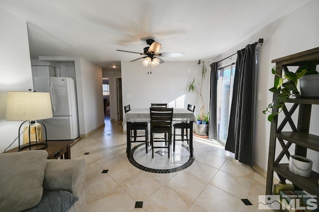 tiled dining area with ceiling fan