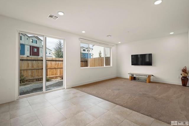 unfurnished living room featuring light colored carpet